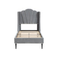 **Lit en velours gris avec tête de lit en forme de vague et pieds en bois**